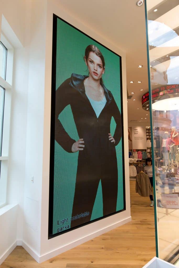 Large-format fashion display inside Uniqlo featuring digital retail graphics and branded visual communications by Gable.