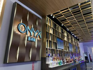 Onyx Bar dimensional wood-wave backdrop echoing the architectural ceiling feature at Choctaw Casino & Resort