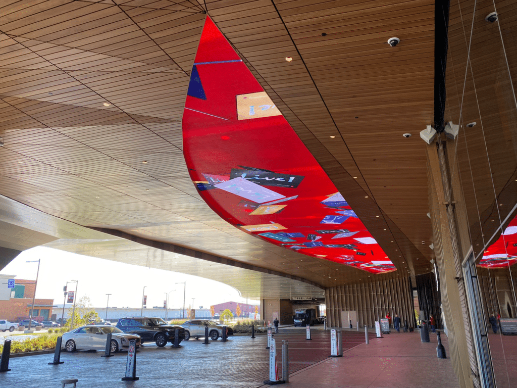 Close-up view of illuminated digital canopy display integrated into a modern wood-clad entrance ceiling.