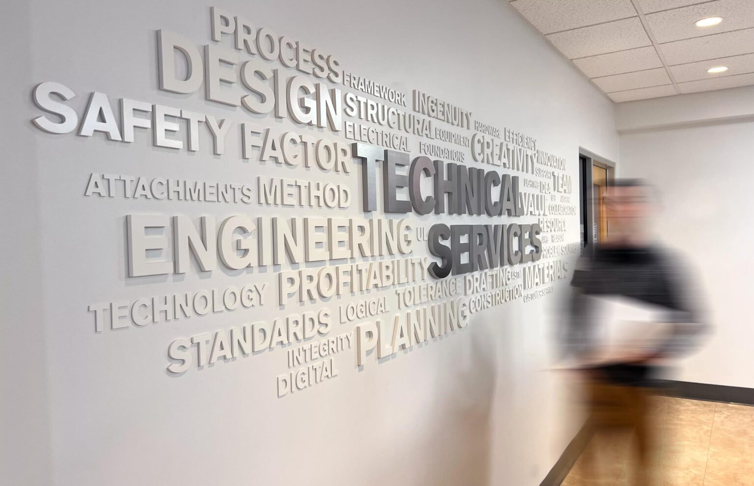 Team Member walking past the Technical Drawings Design Services Department.