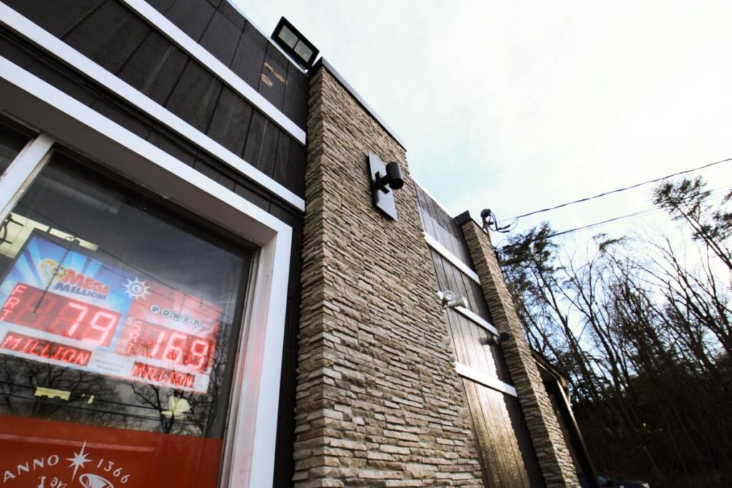 Corwell’s facade detail with architectural materials, exterior lighting, and custom retail signage by Gable.