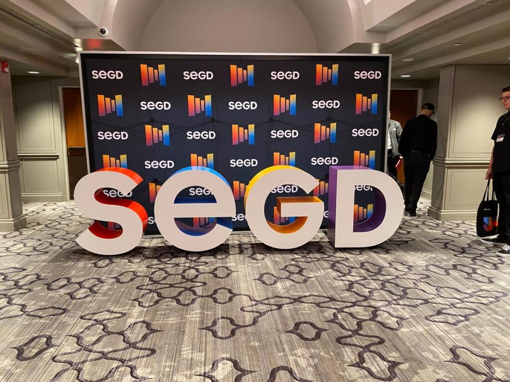 Wide view of SEGD event photo area with branded 3D letters and conference backdrop.