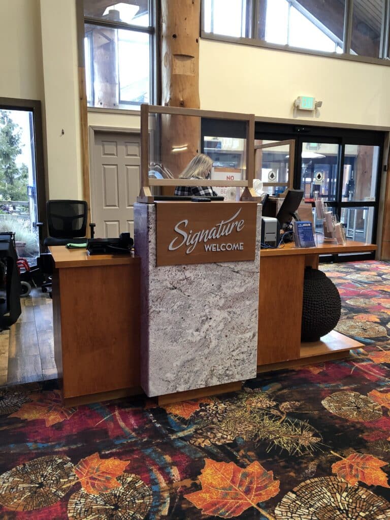 Signature Welcome desk inside Swinomish Casino & Lodge featuring interior wayfinding and branded environmental signage by Gable.