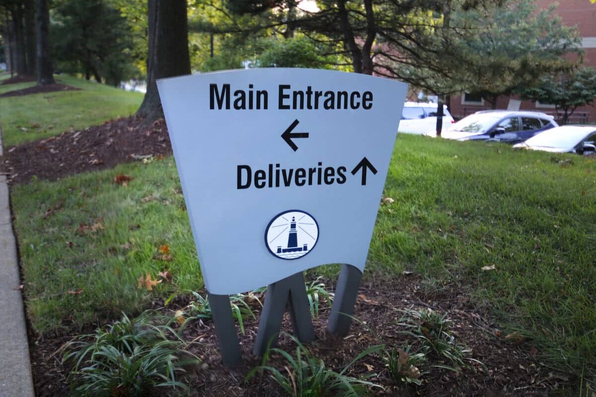 Main entrance and deliveries directional sign with campus wayfinding design by Gable.