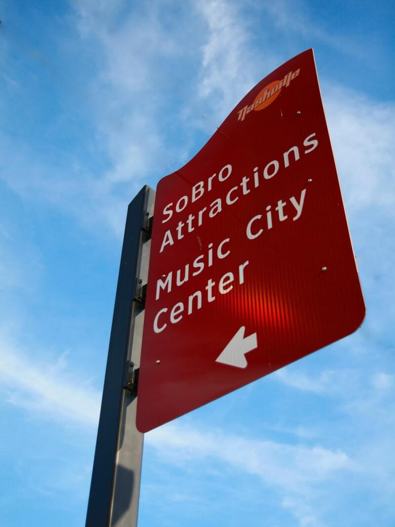 Low-angle view of Music City Center and SoBro attractions wayfinding sign with branded civic signage by Gable.