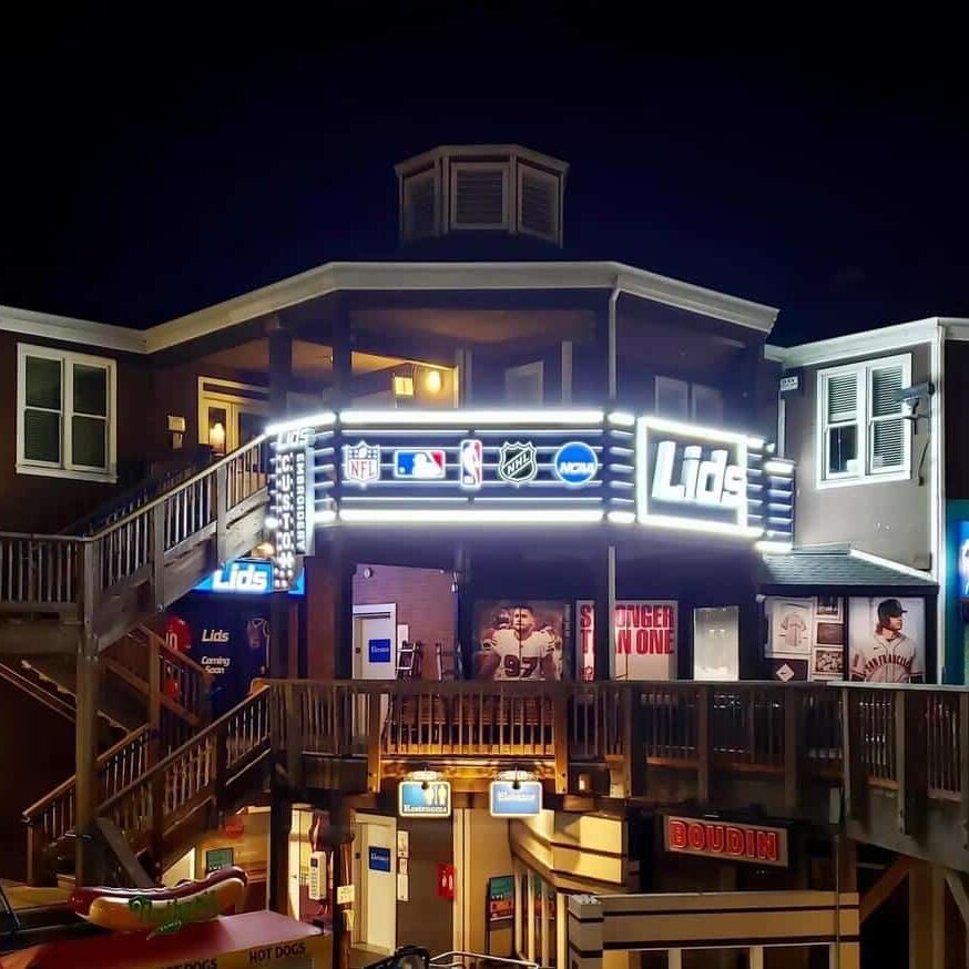 Lids storefront at night with illuminated exterior branding and custom retail signage by Gable.