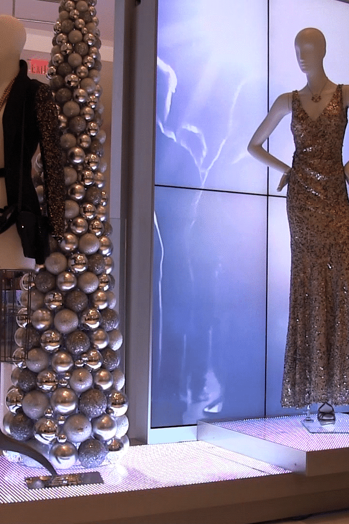Luxury retail window display with illuminated fashion graphics and experiential visual merchandising by Gable.